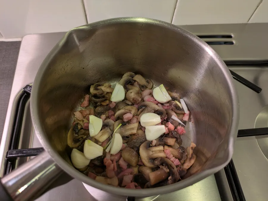 Frying bacon, mushrooms and cloves of garlic